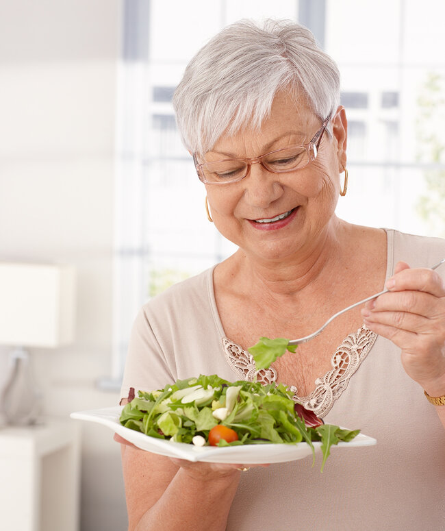Ältere Frau ist Salat